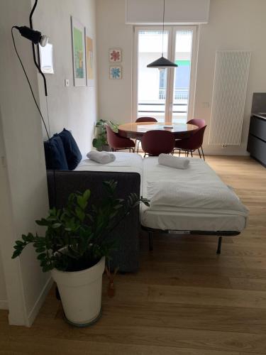 a room with two beds and a table with a plant at Zeus at Como Duomo - Luxury Collection in Como