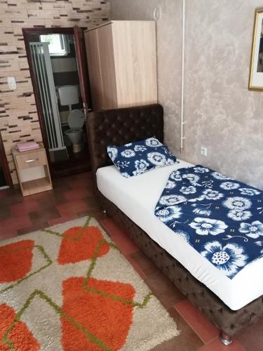 a bedroom with a bed with blue and white pillows at Apartmani Studio in Melenci