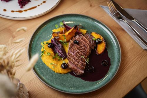 a plate of food with meat and vegetables on a table at Rittis Alpin Chalets Dachstein in Ramsau am Dachstein
