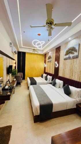 two beds in a hotel room with a ceiling fan at Shri Shyam Hotel, Near Harkipauri in Haridwār