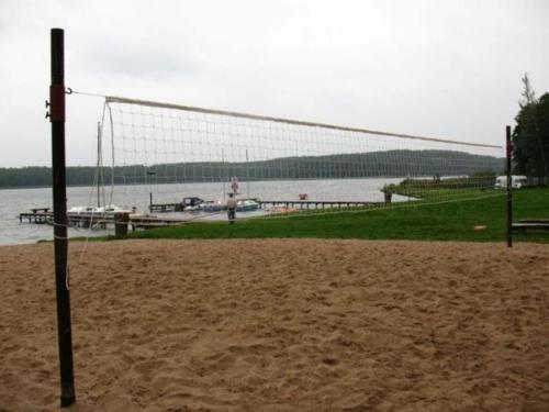a volleyball net on a beach next to a body of water at SAS Militaria dla 2 par 2 pokoje 4 osoby in Borne Sulinowo