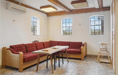 a living room with a red couch and a table at Nice Apartment In Dannemare With Sauna in Dannemare