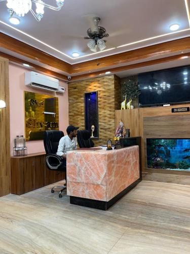 a man sitting at a desk in an office at Shri Shyam Hotel, Near Harkipauri in Haridwār