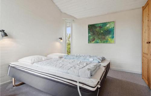 a bed in a bedroom with a painting on the wall at Pet Friendly Home In Thisted With Wifi in Torsted