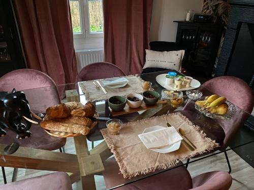 a table with bread and pastries on top of it at Chaleureux in Villiers-en-Lieu
