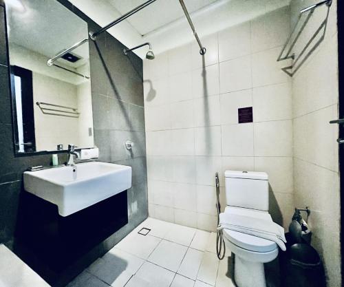 a white bathroom with a sink and a toilet at Suris Boutique Hotel in Kuta