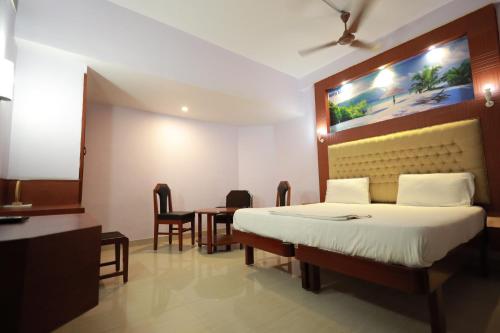 a hotel room with a bed and a table at Hotel Blue Residency in Nāgercoil