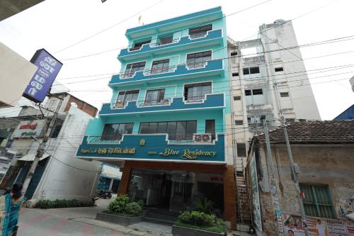 a blue building with a sign in front of it at Hotel Blue Residency in Nāgercoil