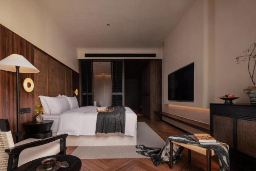 a hotel room with a bed and a flat screen tv at Rong Unique Hotel-Banyan Lake Scenery in Guilin