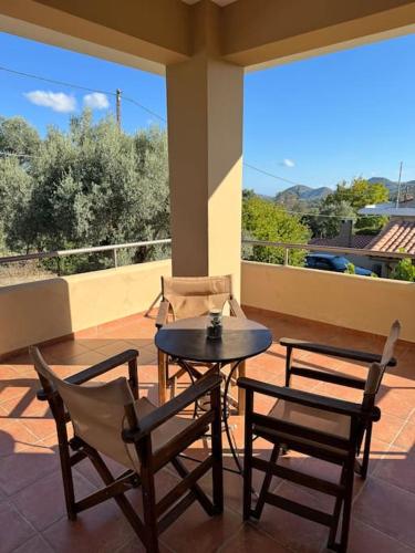 a patio with a table and chairs on a porch at Relaxing home in Taxiárkhai