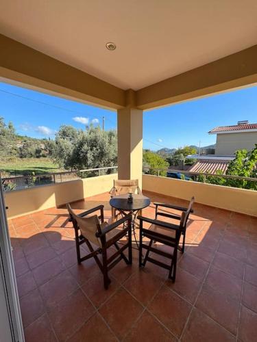 a patio with a table and chairs on a balcony at Relaxing home in Taxiárkhai