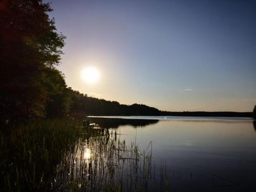 a large body of water with the sun in the sky at BORNE militaria wygodne mieszkanei dla 5 osób in Borne Sulinowo