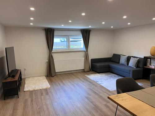 a living room with a blue couch and a television at Neu! Große Ferienwohnung 3 Zimmer mit Küche und Bad, 90 qm mit Netflix und PS5 in Kaiserslautern