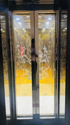 a person standing in front of a glass door at Shri Shyam Hotel, Near Harkipauri in Haridwār