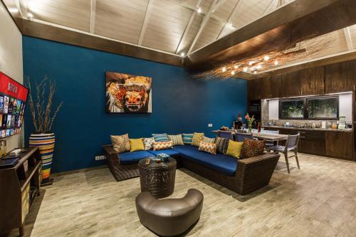 a living room with blue walls and a blue couch at Delight ART Villas in Seminyak