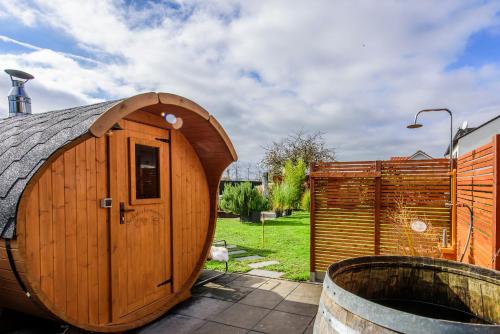 a wooden hobbit house with a wooden tub in a yard at Charming Loft Ferienwohnung Bodensee in Meckenbeuren