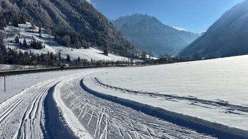 a snow covered road with tracks in the snow at IMBACHHORN Pension in den Alpen in Fusch an der Glocknerstraße