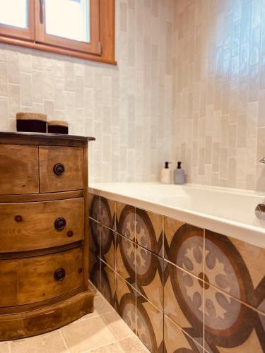 La salle de bains est pourvue d'une baignoire, d'un lavabo et d'une commode. dans l'établissement Maison de montagne Serre Chevalier, à Saint-Chaffrey