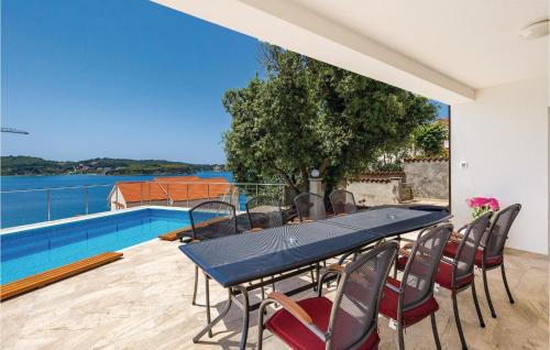a table and chairs on a patio with a swimming pool at Pet Friendly Home In Supertarska Draga in Supetarska Draga