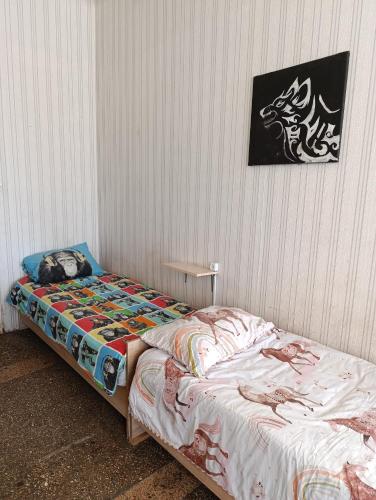 a bed in a room with a picture on the wall at Хостел Sweet Home in Mykolaiv