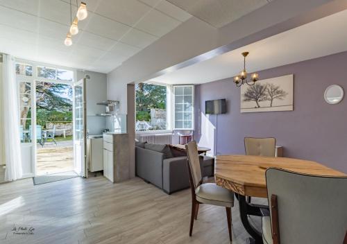 a dining room and living room with a table and chairs at Chambres et Gîtes Les Deux Chênes près de Bergerac in Le Fleix