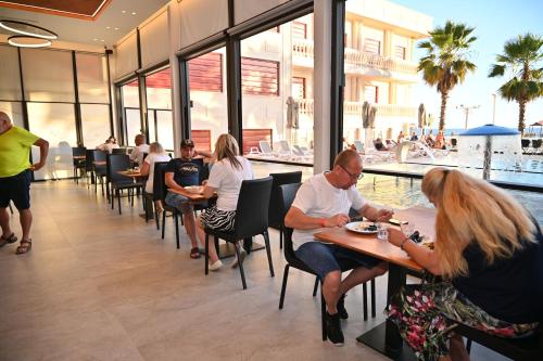 ドゥラスにあるAdria Palaceのレストランのテーブルに座っている人々のグループ