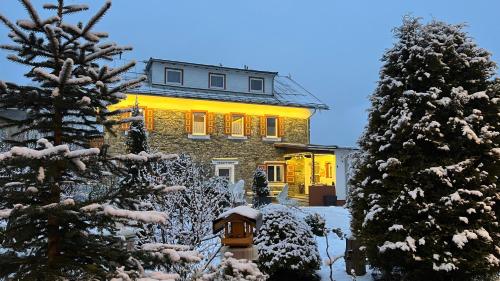 a house with a fire hydrant in the snow at IMBACHHORN Pension in den Alpen in Fusch an der Glocknerstraße