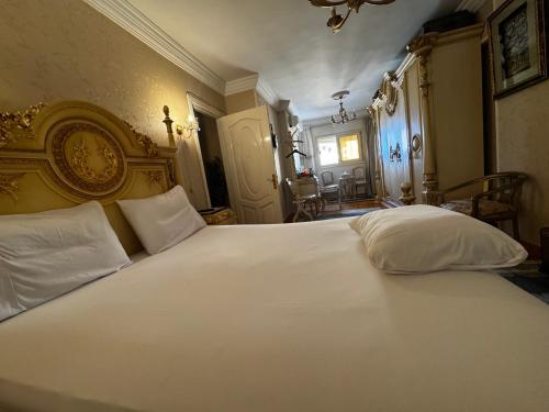 a bedroom with a large white bed with white pillows at center of Alexandria in Alexandria