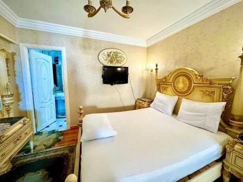 a bedroom with a white bed and a television at center of Alexandria in Alexandria