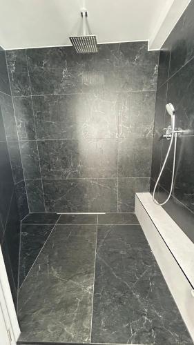 a bathroom with a shower with a black tiled wall at Ferienwohnung Soest Lendringsen in Soest