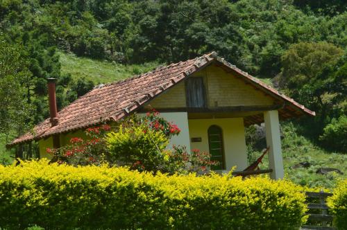 a small yellow house with a tiled roof at Pousada Pé da Mata in Aiuruoca