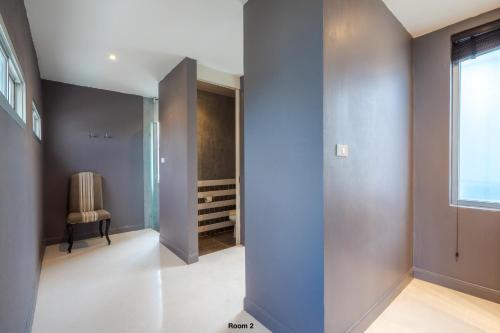 a hallway with blue walls and a chair at Venice Beach Village Hua Hin Pool Villa in Cha Am