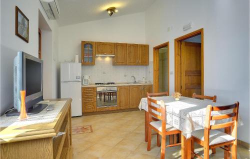 a kitchen with a table with chairs and a dining room at Beautiful Apartment In Rakalj With Wifi in Rakalj