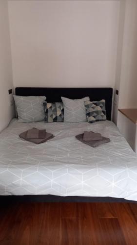 Elle comprend un grand lit avec des draps et des oreillers blancs. dans l'établissement Very Nice Apartment, à Nice