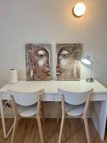 - deux œuvres d'art sur un bureau avec deux chaises dans l'établissement Le Joly studio - centre ville - métro - tramway, à Toulouse