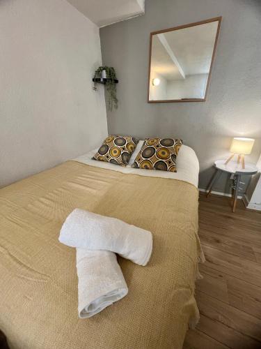 une chambre avec un lit avec deux serviettes dessus dans l'établissement Le Joly studio - centre ville - métro - tramway, à Toulouse
