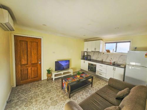 ein Wohnzimmer mit Couch und Küche in der Unterkunft Realhome in Blacktown