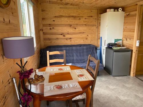 - une table et des chaises dans une pièce avec cuisine dans l'établissement Chalet autonome à louer sur terrain de loisir de 2000m2 avec étang privé, à Manou