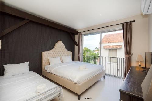 a bedroom with two beds and a balcony at Venice Beach Village Hua Hin Pool Villa in Cha Am