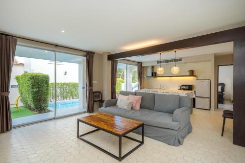 a living room with a couch and a table at Venice Beach Village Hua Hin Pool Villa in Cha Am