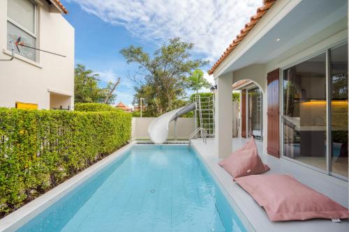a pool in the backyard of a house with a water slide at Venice Beach Village Hua Hin Pool Villa in Cha Am