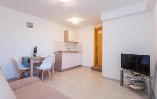 a living room with a television and a table with chairs at One-Bedroom Apartment In Ploce in Blace