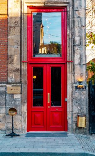 a red door on a building with a statue at Communal Hotel Kutaisi in Kutaisi