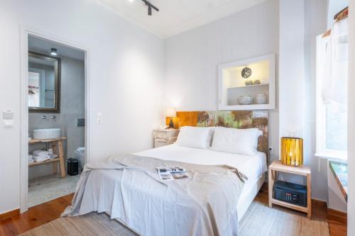 a white bedroom with a bed and a bathroom at Amymone and Adiandi in Nafplio