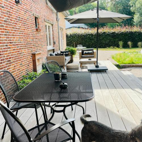 a patio with a table and chairs and an umbrella at Domaine Bourgogne en Grez "Terre d'Héritage" in Grez-Doiceau