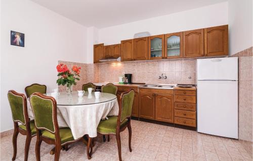 a kitchen with a table with chairs and a white refrigerator at Apartment Drfranje Tudmana I in Turanj