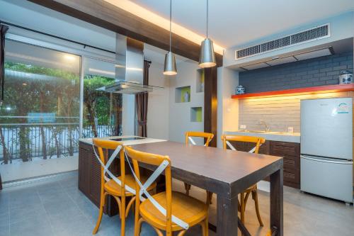 a kitchen with a wooden table and yellow chairs at Venice Beach Village Hua Hin Pool Villa in Cha Am