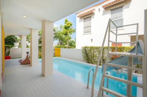 a house with a swimming pool and a staircase at Venice Beach Village Hua Hin Pool Villa in Cha Am