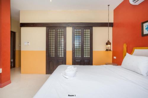 a bedroom with a white bed and orange walls at Venice Beach Village Hua Hin Pool Villa in Cha Am
