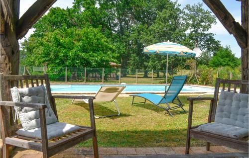 two chairs and an umbrella next to a pool at Nice Home In Église-Neuve-D'issac in Saint-Jean-dʼEyraud